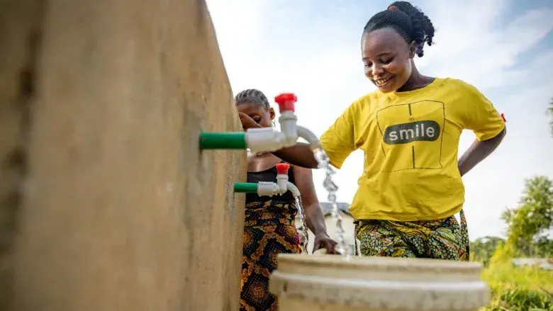 Woman fetches water at a new public standpipe in Kutu Territory, Mai-Ndombe Province, built through community benefit sharing revenues under the ERPA, with support from the World Bank's Forest Carbon Partnership Facility (FCPF).